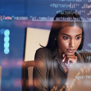 Pictorial representation of a BadSuccessor attack. A person analyzing data on a computer screen in a busy office environment, with digital graphs and code overlaying the image.