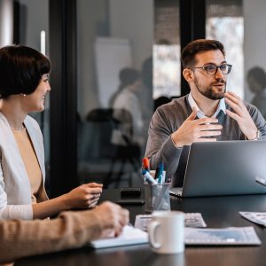 Pictorial representation of a group of individuals conversing in an office setting.