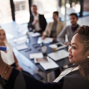 Pictorial representation of a group of individuals discussing an idea with a whiteboard.