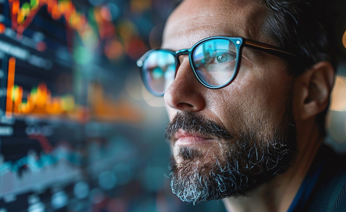 Pictorial representation of a man with glasses viewing a monitor of code.