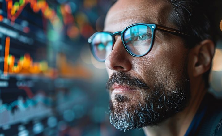 Pictorial representation of a man with glasses viewing a monitor of code.