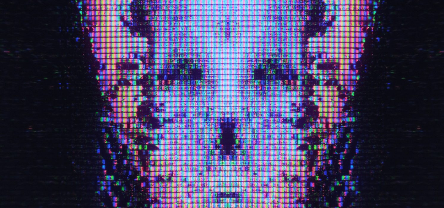 Pictorial representation of Gremlin Stealer hiding in plain sight. Close-up view of a digital screen displaying a glitched and pixelated image of a skull-like shape.