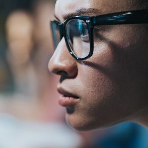 Pictorial representation of a severe Linux vulnerability. Close-up of a woman wearing glasses and focusing intently on a computer screen.